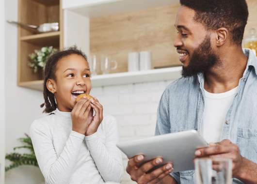 girl-eating-cookie-dad-on-ipad