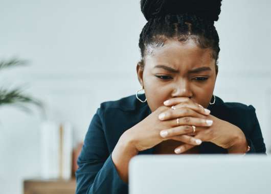 Woman with hands over mouth staring at a computer