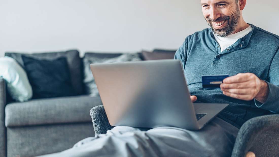 man using credit card on computer
