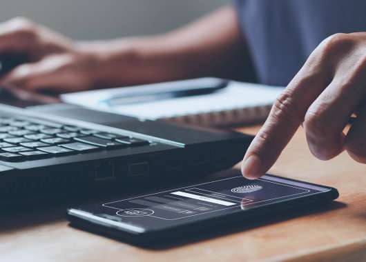 Finger using thumbprint software to verify identity.