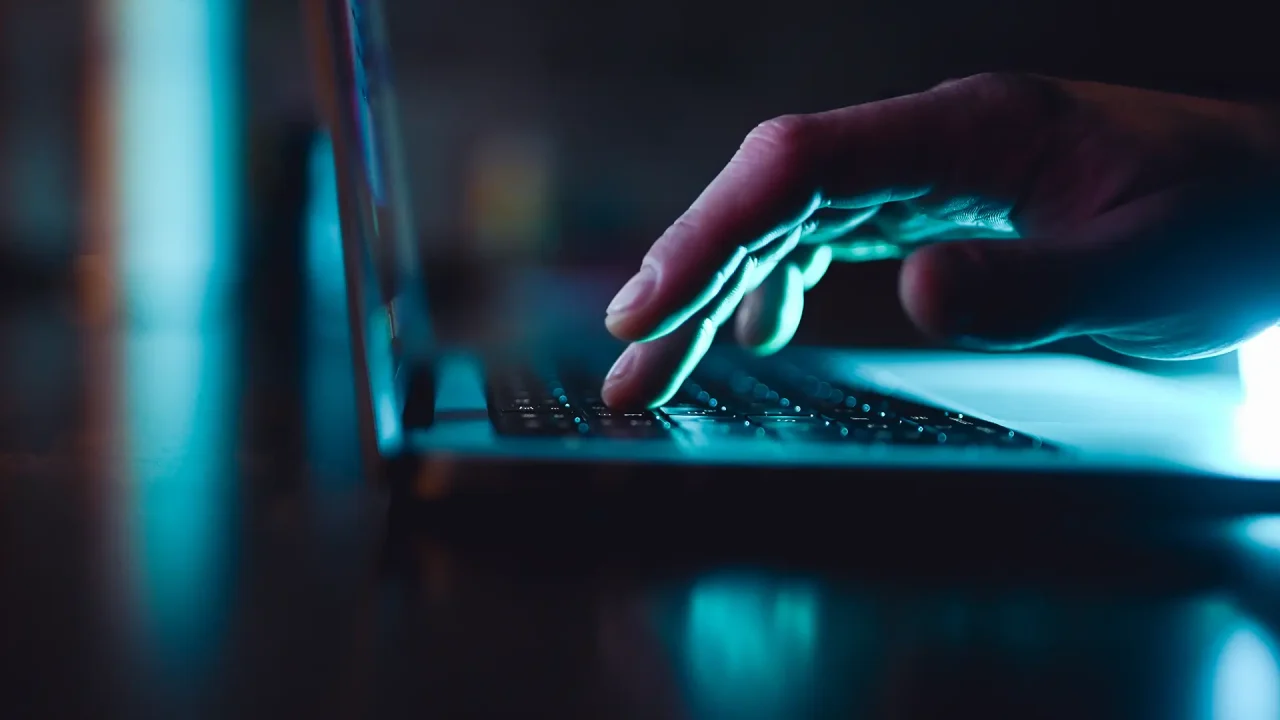 A man’s hand browsing on a laptop.